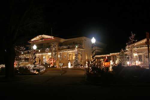 A beautifully decorated building at night, adorned with festive lights and Christmas trees.