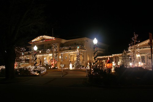 A beautifully decorated building at night, adorned with festive lights and Christmas trees.