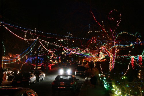 A festive street illuminated with colorful holiday lights, creating a vibrant and cheerful nighttime scene.
