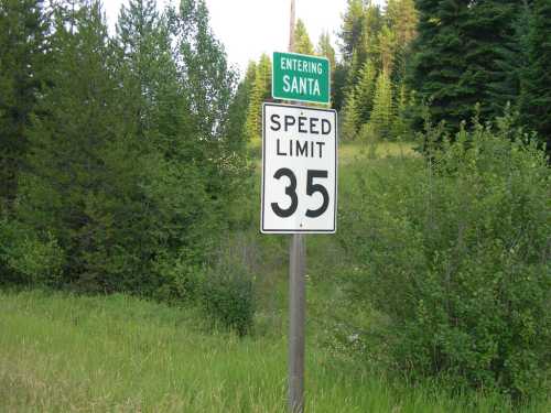 A road sign indicating "Entering Santa" and a speed limit of 35 mph, surrounded by greenery and trees.