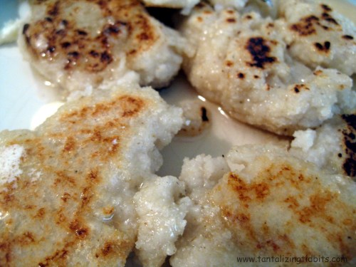 Close-up of golden-brown, crispy flatbreads served on a plate, glistening with a light drizzle of oil.