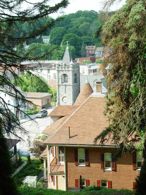 A view of a town with a clock tower, surrounded by trees and buildings, showcasing a peaceful, scenic landscape.