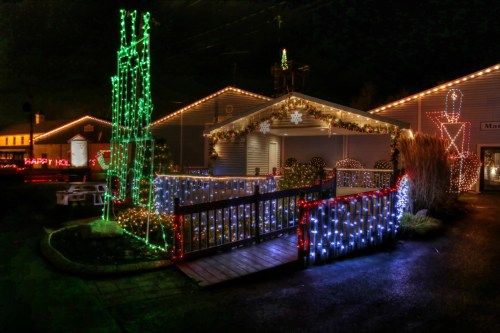 A festive display of colorful holiday lights on a building and surrounding area, creating a cheerful nighttime scene.