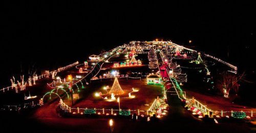 Aerial view of a festive display with colorful Christmas lights illuminating a park at night.