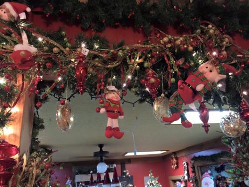 Colorful Christmas decorations featuring Santa, an elf, and ornaments hanging from a garland with lights.