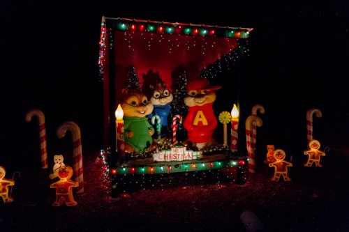 A festive display featuring animated chipmunks in Christmas attire, surrounded by candy canes and gingerbread decorations.