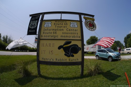 Sign for Henry's Rabbit Ranch on Route 66, featuring a rabbit graphic and information about souvenirs and memorabilia.