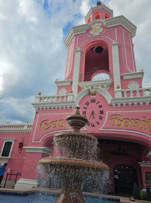A pink building with a clock tower and fountain in front, featuring the words "Casino Bonita" in bright letters.