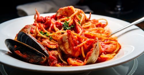 close up photo of seafood pasta with tomato sauce, mussels, clams, and shrimp