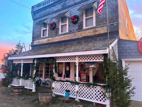 A charming old building decorated for the holidays, featuring wreaths, a porch, and an American flag.