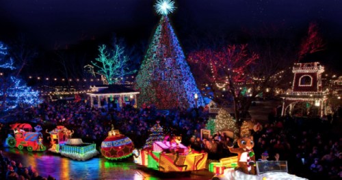 A festive scene with a brightly lit Christmas tree, colorful decorations, and a parade of illuminated floats in a crowd.
