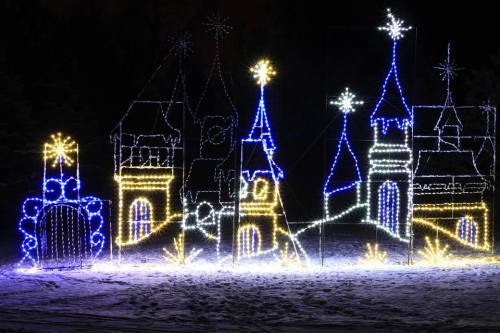 A colorful display of illuminated castle-like structures with stars, set against a dark background.