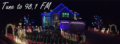A beautifully decorated house with colorful holiday lights and festive displays, inviting viewers to tune to 98.1 FM.
