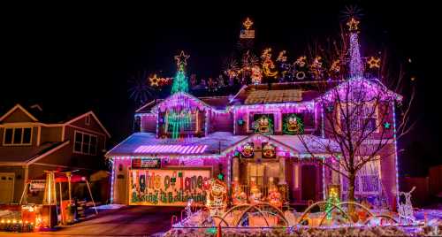 A brightly lit house decorated with colorful Christmas lights and festive ornaments, glowing in the night.