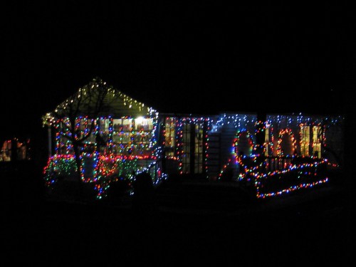 A house decorated with colorful Christmas lights, glowing brightly against the night sky.