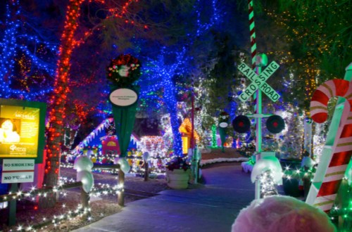 A festive pathway adorned with colorful Christmas lights, candy canes, and holiday decorations.