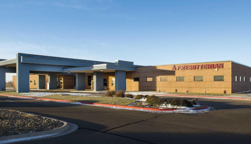 A modern Presbyterian building with a clear blue sky and landscaped surroundings.
