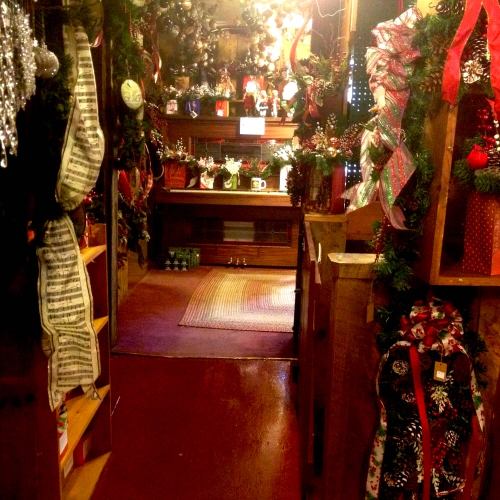 A cozy, festive room decorated with holiday wreaths, lights, and ornaments, creating a warm, inviting atmosphere.