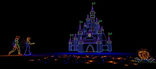 Colorful holiday lights depict a castle, a couple, and a pumpkin against a dark background.