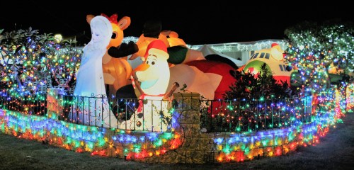 Colorful holiday display featuring inflatable characters and vibrant lights in a festive nighttime setting.