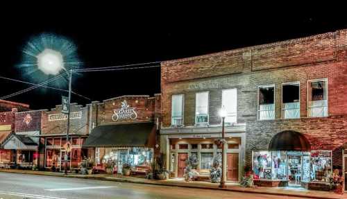 A charming street scene at night featuring historic brick buildings and festive decorations.