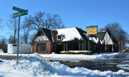 A snow-covered building at the corner of Jefferson and Cortez Kennedy, with a sign for "Wilson's Café."