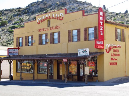 Historic Overland Hotel and Saloon, featuring a yellow exterior with signage and a porch in a rustic setting.