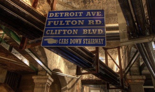 Sign indicating street names: Detroit Ave, Fulton Rd, Clifton Blvd, with an arrow pointing down a stairway.