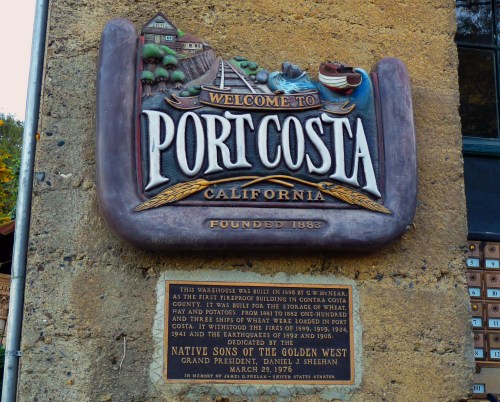 Sign welcoming visitors to Port Costa, California, with historical details and founding date of 1883.