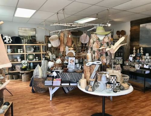 A cozy shop filled with home decor items, including baskets, textiles, and decorative accessories on display.