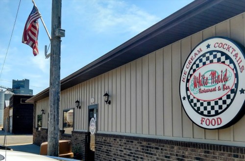 Exterior of White Mart's Restaurant & Bar, featuring an American flag and a sign for ice cream and cocktails.