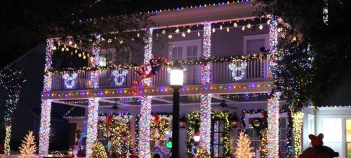 A festive house decorated with colorful Christmas lights and ornaments, glowing brightly at night.