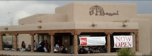 Exterior of El Parasol restaurant with a "Now Open" banner and a crowd visible on the patio.