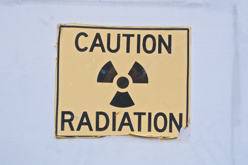 A yellow caution sign displaying a radiation symbol and the word "RADIATION."