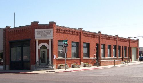 Historic brick building with large windows, located at a street corner, featuring decorative architectural details.