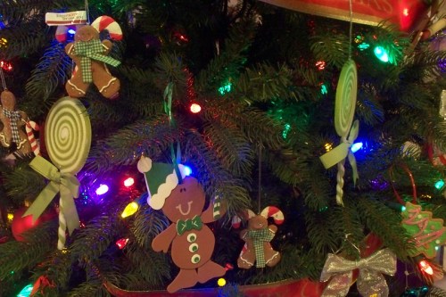 Colorful Christmas tree adorned with gingerbread ornaments, candy canes, and festive lights.