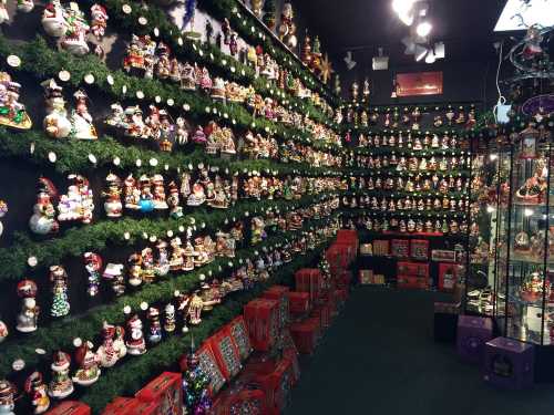 A festive display of numerous decorative figurines and gift boxes arranged on walls and shelves in a holiday-themed store.