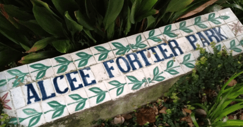 Sign for Alcee Fortier Park, featuring decorative tiles with green leaves and blue lettering.