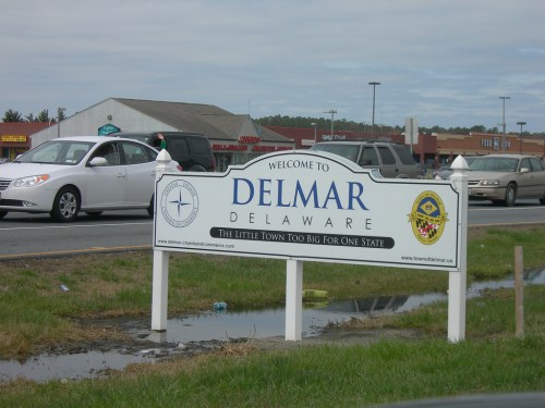 Sign welcoming visitors to Delmar, Delaware, with the slogan "The Little Town Too Big for One State."
