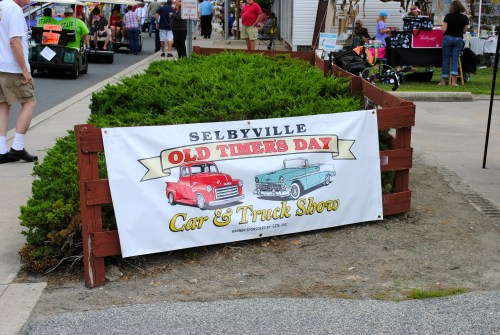 A banner for the Selbyville Old Timers Day Car & Truck Show, featuring classic cars and a festive atmosphere.