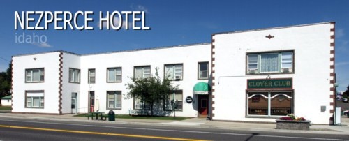 Exterior view of the Nezperce Hotel in Idaho, featuring a white building with green and red accents.