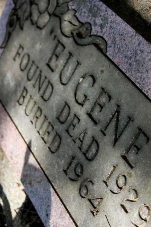 A weathered grave marker inscribed with "Eugene, found dead 1929, buried 1964."