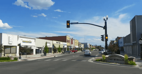 A street view of Fort Morgan with shops, traffic lights, and a clear blue sky.