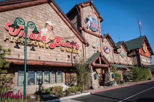 Exterior of Uncle Buck's Fish Bowl & Grill, featuring a rustic design and colorful signage against a clear blue sky.