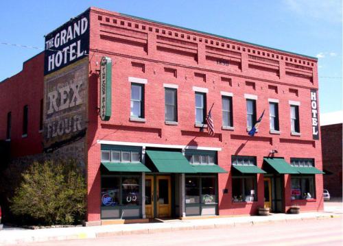Historic red brick building with green awnings, featuring signs for "The Grand Hotel" and "Rex Flour."