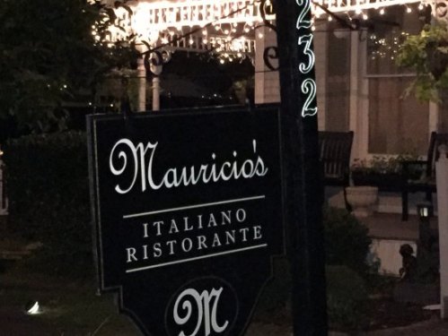 Sign for Mauricio's Italiano Ristorante, illuminated with string lights in the background.