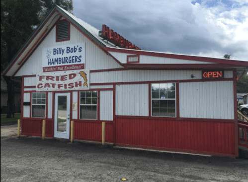 A red and white building with a sign for "Billy Bob's Hamburgers" and "Fried Catfish," featuring an "OPEN" sign.