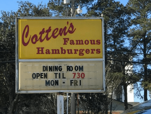 Sign for Cotten's Famous Hamburgers, stating dining room hours: open until 7:30 PM, Monday to Friday.