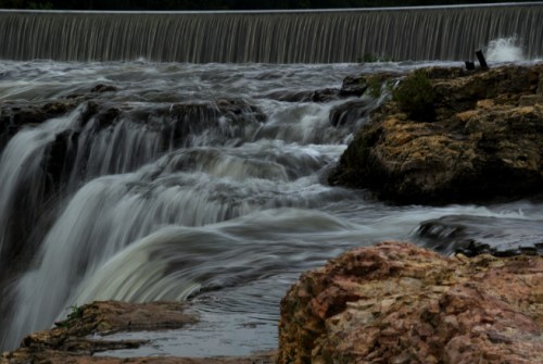 A serene waterfall cascading over rocky terrain, creating a smooth flow of water in a natural setting.