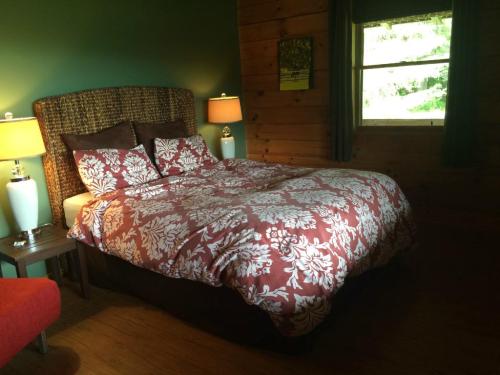Cozy bedroom with a large bed, floral bedding, wooden walls, and soft lighting from bedside lamps.